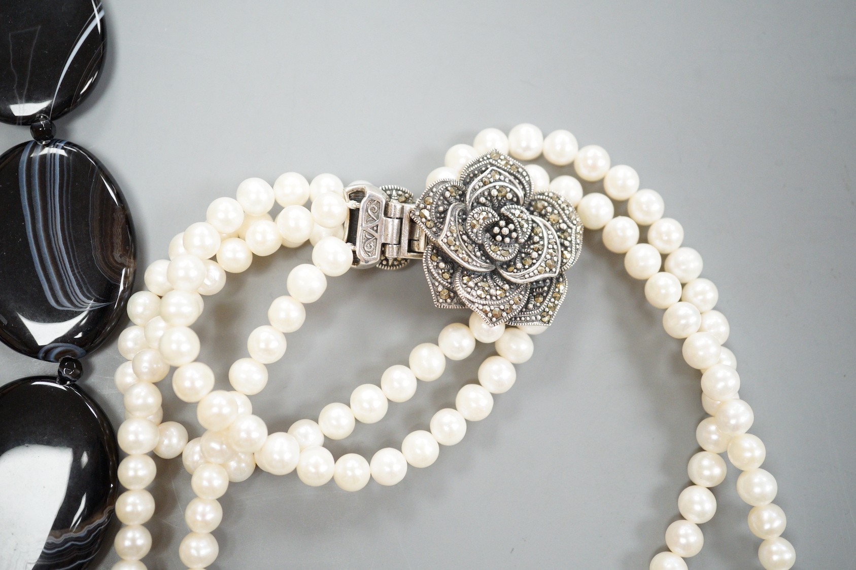 A double strand freshwater pearl necklace, with marcasite set clasp, a banded black agate necklace with 925 clasp and freshwater pearl, amethyst and agate set necklace.
